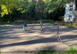 Chłopiec i dziewczynka grają w piłkę nożną. Dziewczynka celuje do bramki